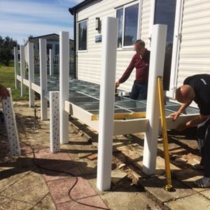 Balustrades being erected as part of a cream uPVC deck