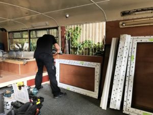 Team working on the interior of the bus, fitting Liniar windows 
