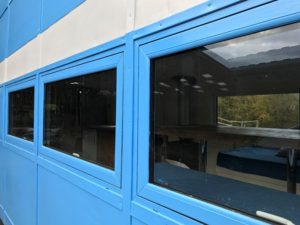 Finished image of Liniar windows painted a bright blue on the side of a vintage bus