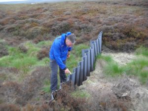 Liniar's Outdoor Sales Director Mark Sims investigating the plastic piling installed on the moors during Liniar's Land Rover Safari