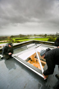 Storm clouds loom over installers as they put the bars down for an Elevate lantern roof 